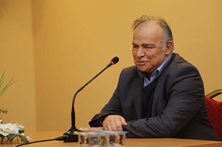 Gazeteci Avni Özgürel konuşma yaptığı sırada görünüyor.