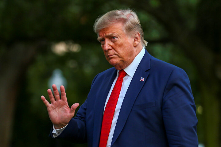 ABD Başkanı Donald Trump gazetecileri selamlarken görünüyor.