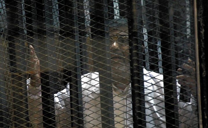 Muhammed Mursi, 2011'de Hüsnü Mubarek'in devrilmesine yol açan devrimin yarattığı kaosun ortasında ''hapishane baskını'' organize etmekle suçlandığı davada yargılanırken.