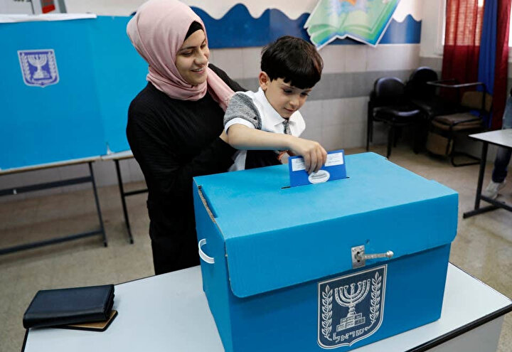 Seçimlerde oğluyla birlikte oy kullanan Arap kökenli bir İsrail vatandaşı.