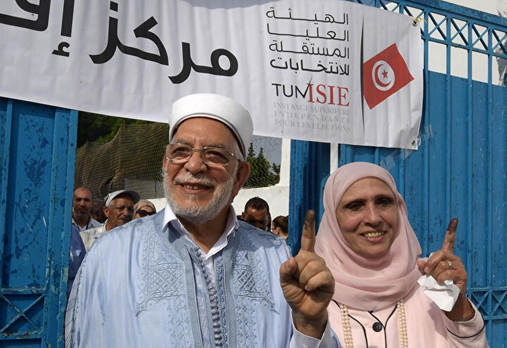Nahda Hareketi'nin adayı Abdulfettah Moro ve karısı oy kullandıktan sonra mürekkebe batırdıkları parmaklarını gazetecilere gösteriyor.