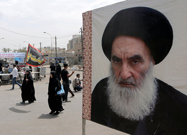 Sağ tarafta Şiilerin en büyük dini lideri Ali es-Sistani'nin posteri görülüyor.
