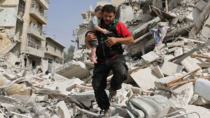 Ala'nın Halep'te 2016 yılında bir çocuğu enkaz altından çıkardıktan sonra çekilen fotoğrafı.