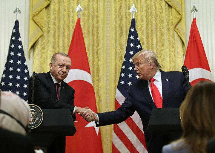 Basın toplantısı için kürsüde yerini alan liderler samimi bir şekilde tokalaşıyor.