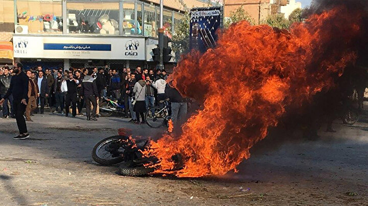Gösteriler sırasında ateşe verilen bir motosiklet.