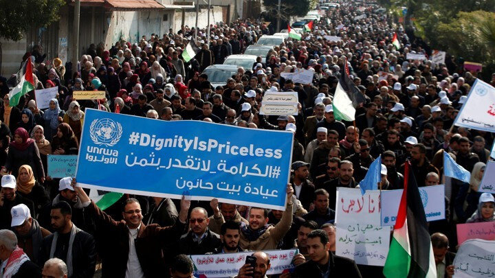 ABD'nin Filistin'e mali yardımda bulunmayacağını açıklamasının ardında durumu protesto eden Birleşmiş Milletler Filistinli Mültecilere Yardım Ajansı çalışanları ''İzzet/haysiyete fiyat biçilmez'' yazan pankartlarıyla.