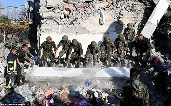 Deprem sonrası beton blokları hareket ettirmeye çalışan görevliler.