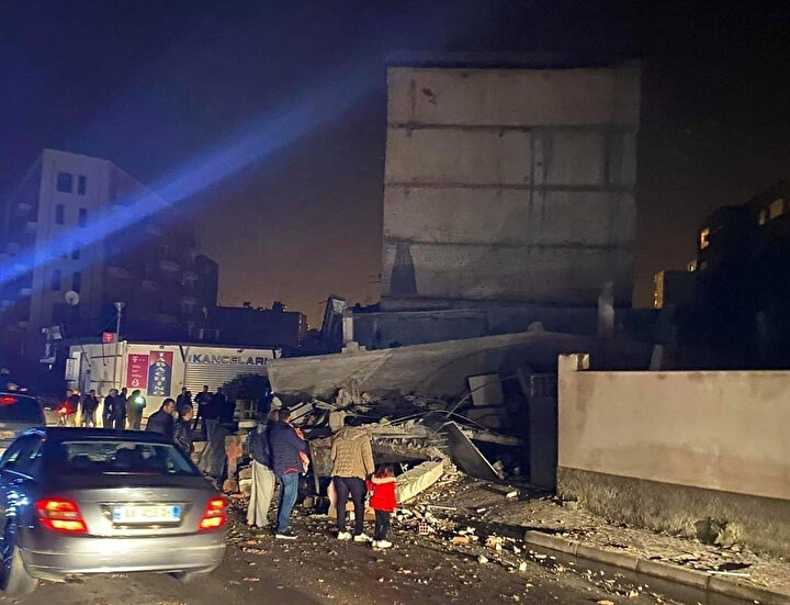 Depremin hemen sonrası insanlar hasar gören binaları inceliyor.