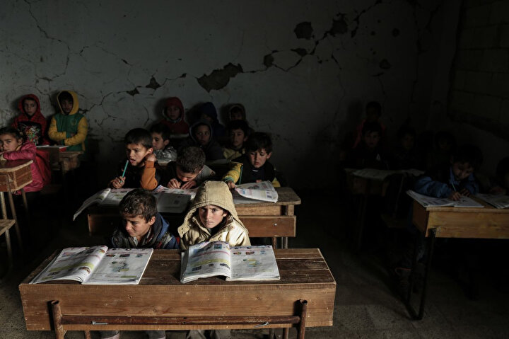 Suriyeli çocuklar, İdlib’de hasarlı Al Kefir okulunda sınıflarında ders görüyor. Suriye rejiminin 2015-2016 yılları arasında gerçekleştirdiği saldırıların yol açtığı yıkıma rağmen 200'den fazla öğrenci okula devam ediyor.