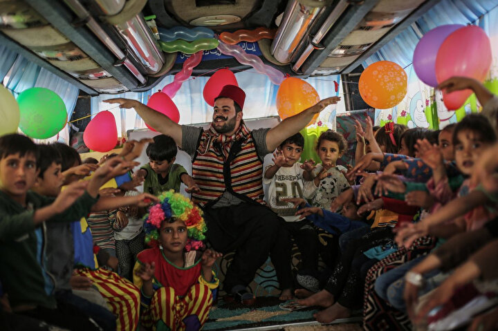 22 Eylül 2019, Suriye, Hazano: Suriyeli bir öğretmen, sınıfa dönüştürülen otobüsün içinde öğrencilerle interaktif bir oyun oynuyor.