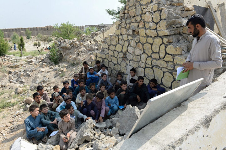 22 Temmuz 2019, öğrenciler, Afganistan'ın Nengrehar vilayetinin Deh Bala bölgesinde Papen Lisesi'nden geriye kalan yıkıntıların arasında ders görüyor.