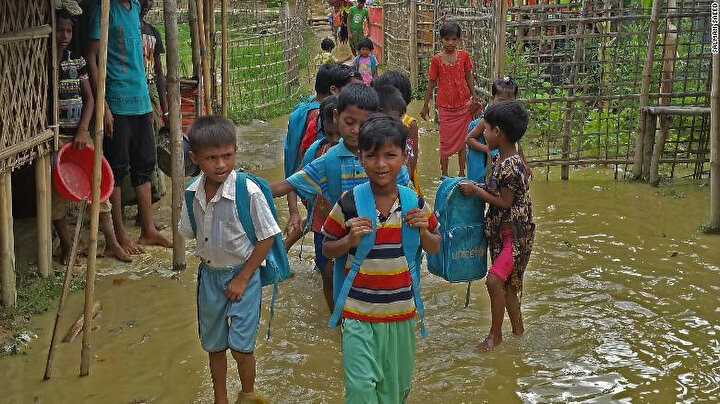 Bangladeş'teki mülteci kampındaki Arakanlı çocuklar birikmiş sel sularından geçerek kamptaki eğitim merkezlerine gidiyor.