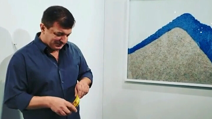 Aç sanatçı muzu soyarken