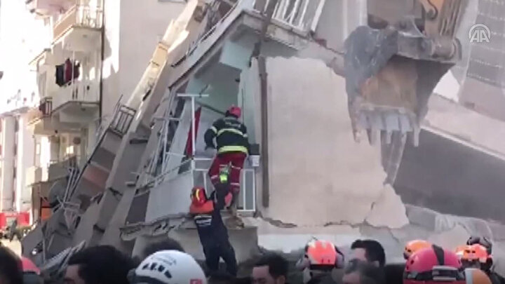 İtfaiye erleri enkazdan Türk bayrağını alırken