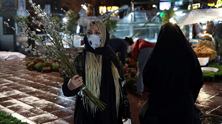 İran'da Nevruz için alışverişe çıkan kadın, koronavirüs salgınından maskeyle korunmaya çalışıyor.