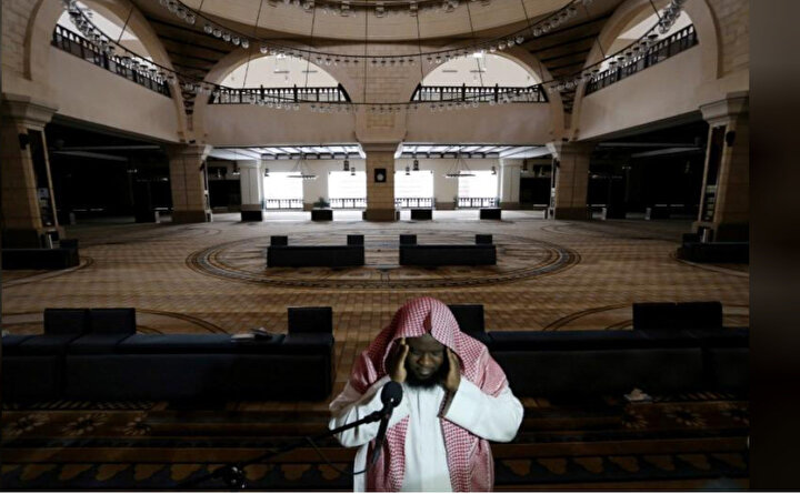Koronavirüsün yayılmasıyla cuma namazlarının askıya alındığı Suudi Arabistan'da cemaatin olmadığı camide ezan okuyan bir müezzin.
