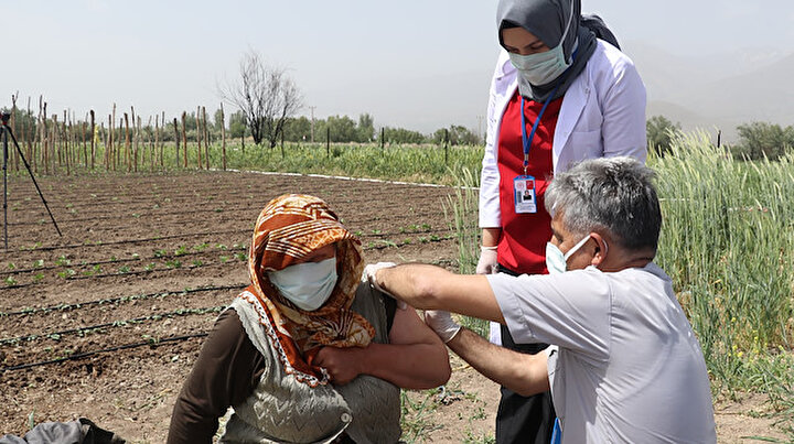 Hastaneye gitme fırsatı bulamayan çiftçi aile Kovid aşısını çapa yaptıkları tarlada oldu