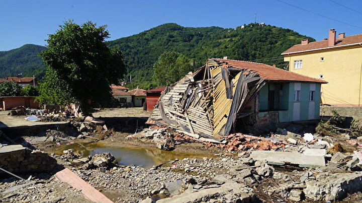 Selde yıkılan bina suların yönünü değiştirdi: 8 kişinin hayatı kurtuldu