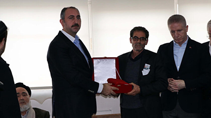 Bakan Gül, baba Mustafa Yanık'a, Türk bayrağına sarılı Kur'an-ı Kerim hediye etti.
