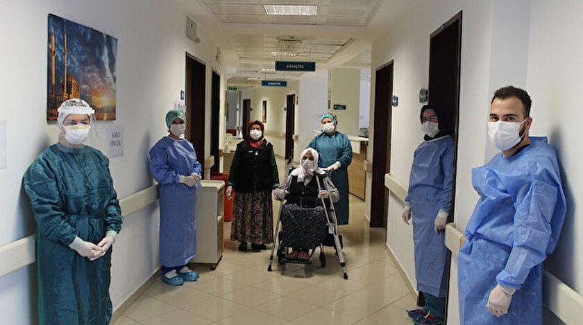 Yaşlı kadın sağlık çalışanlarının eşliğinde taburcu edildi.