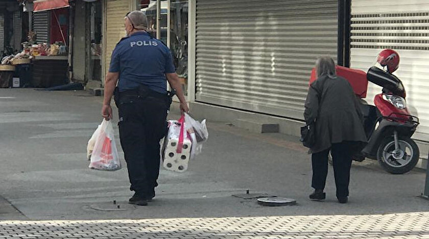 Polis yaşlı kadının market poşetlerini evine kadar taşıdı