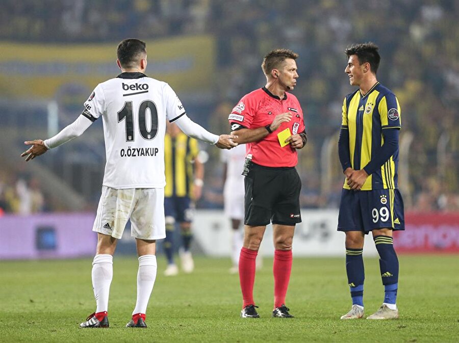 Derbinin hakemi Fırat Aydınus, siyah beyazlılarda Oğuzhan Özyakup'a sarı kart gösteriyor.