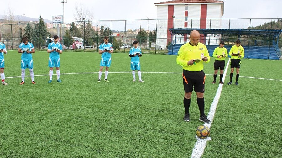Futbolcular ve hakemler kitap okuyor.