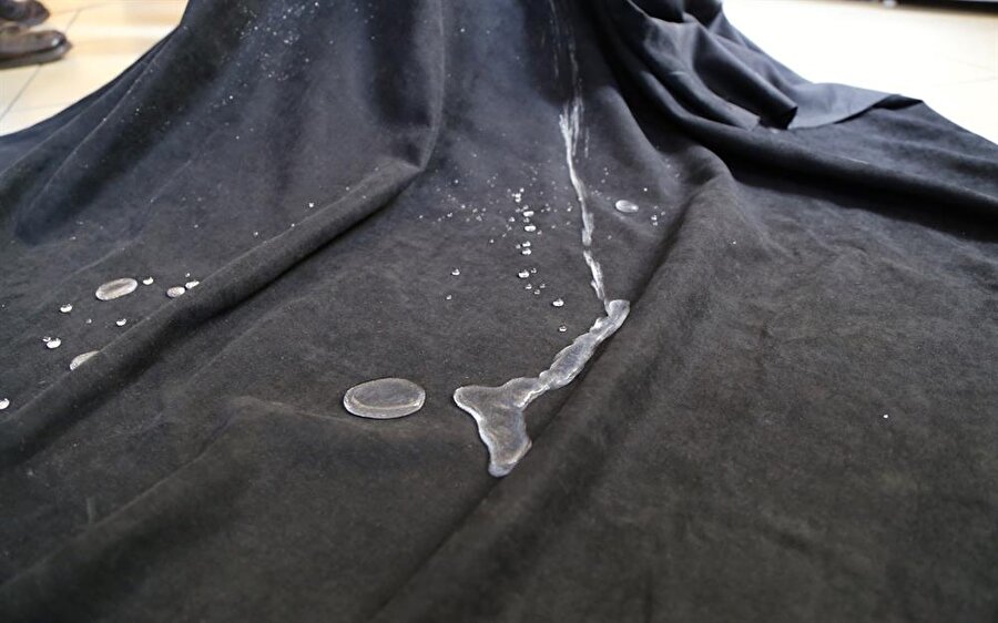 Uzun süren laboratuvar çalışmalarının sonucunda geliştirilen, silisyum ve titanyum bazlı hidrofobik sıvı malzeme ile gerçekleşen deneyde, kumaş ve kağıt üzerine uygulama yapıldı.