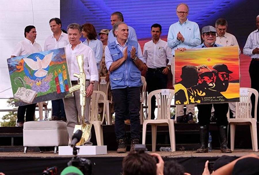 "Tek silahımız sözümüz olacak." yazılı beyaz tişörtlerle alanda yerlerini alan FARC militanları ve diğer konukları önce Jean Arnault selamladı.