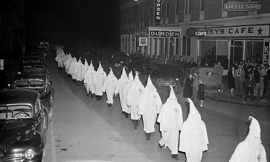 Ku Klux Klan üyeleri önceden uzun elbiseleri ve beyaz maskeleriyle sokakta yürüyüş düzenliyordu.