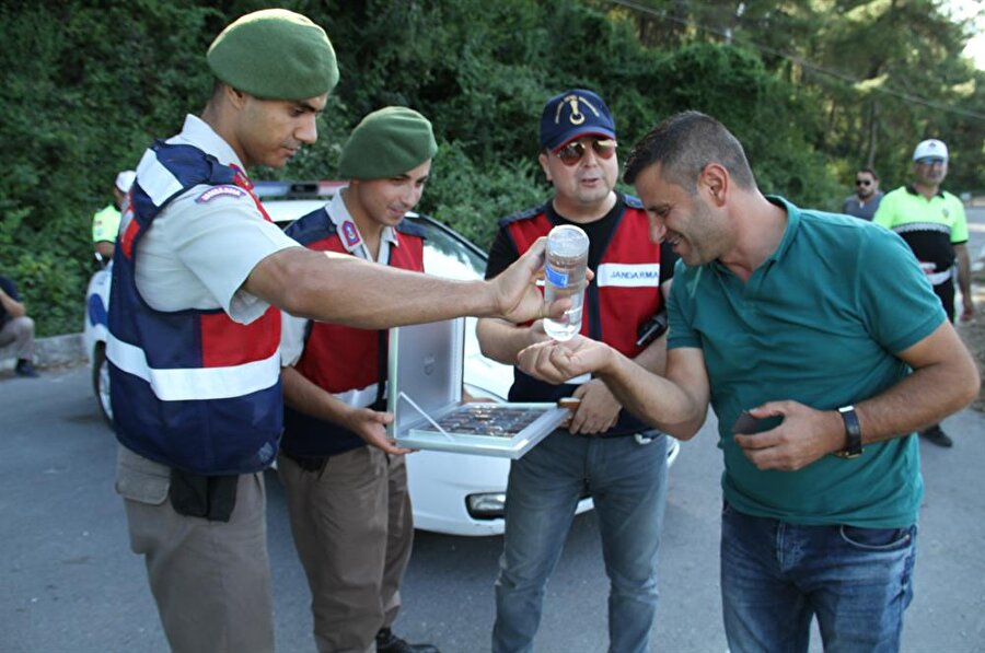 Samsun'un Yakakent ilçesinde uygulama noktasında durdurulan sürücülere, kolonya ve çikolata ikram edildi. (Emre Şahinol / AA)