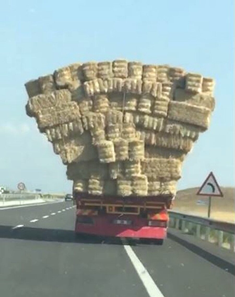 Üzeri aşırı saman balyaları yüklü kamyonun tehlikeli yolculuğu görenleri hayrete düşürdü.