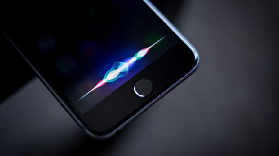 Apple iPhone Siri, şu anda fiziksel ana menü tuşuna uzun süre basıldığında devreye giriyor ve sesli komutları algılamaya hazır hale geliyor. 