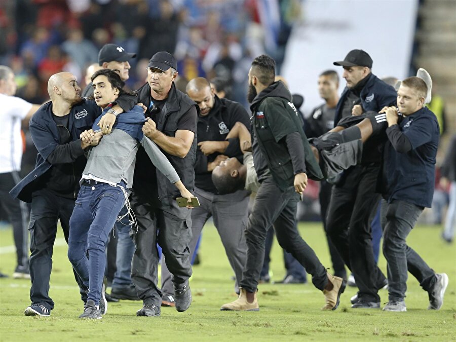 Maç devam ederken sahaya giren holiganlar polis tarafından zor zaptedildi.