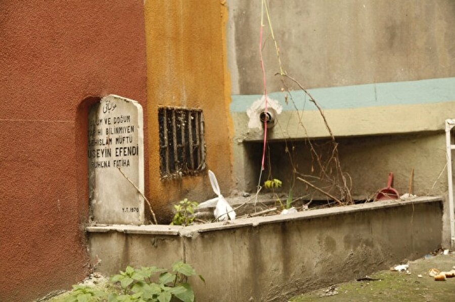Mezarın yarısı binanın altında kalmış.