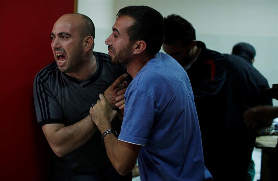 Filistinliler, olaylarda hayatlarını kaybeden yakınlarının cenazelerini teslim alıyor. (Mohammed Salem / Reuters)