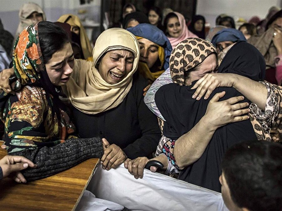 Peşaver saldırısında hayatını kaybeden çocukların yakınları, cenaze töreni sırasında.