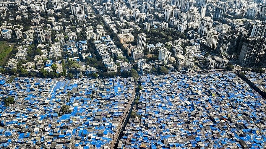 Mumbai, Hindistan - Mavi muşambalar muson yağmurlarından korunmak için çatılara seriliyor.