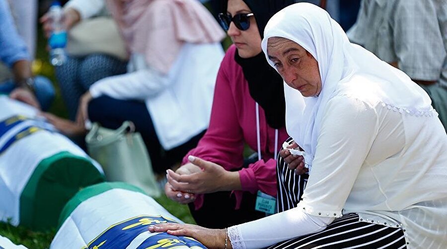 Kimlik tespiti yapılan kurbanlar aileleri tarafından toprağa veriliyor. (Fotoğraf: Anadolu Ajansı)