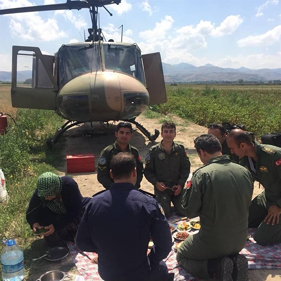 Afyonkarahisar'da arızalanan "UH-1H" tipi askeri helikopterin personeli, acil iniş yaptıkları köyde, vatandaşların evlerinden getirdiği yiyeceklerle kurdukları yer sofrasında ağırlandı.