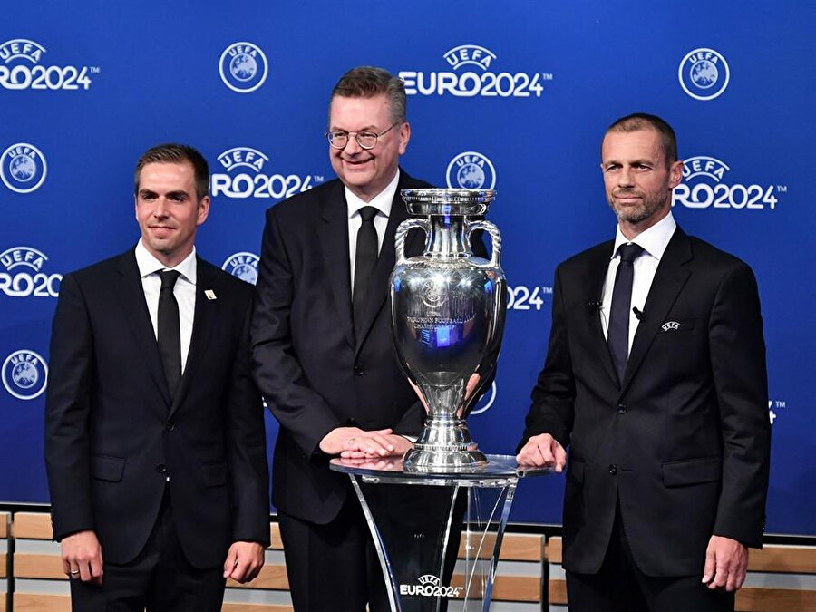 UEFA Başkanı Aleksander Ceferin, Almanya Futbol Federasyonu Başkanı Reinhard Grindel ve Philipp Lahm kupa ile birlikte basın mensuplarına poz veriyor.