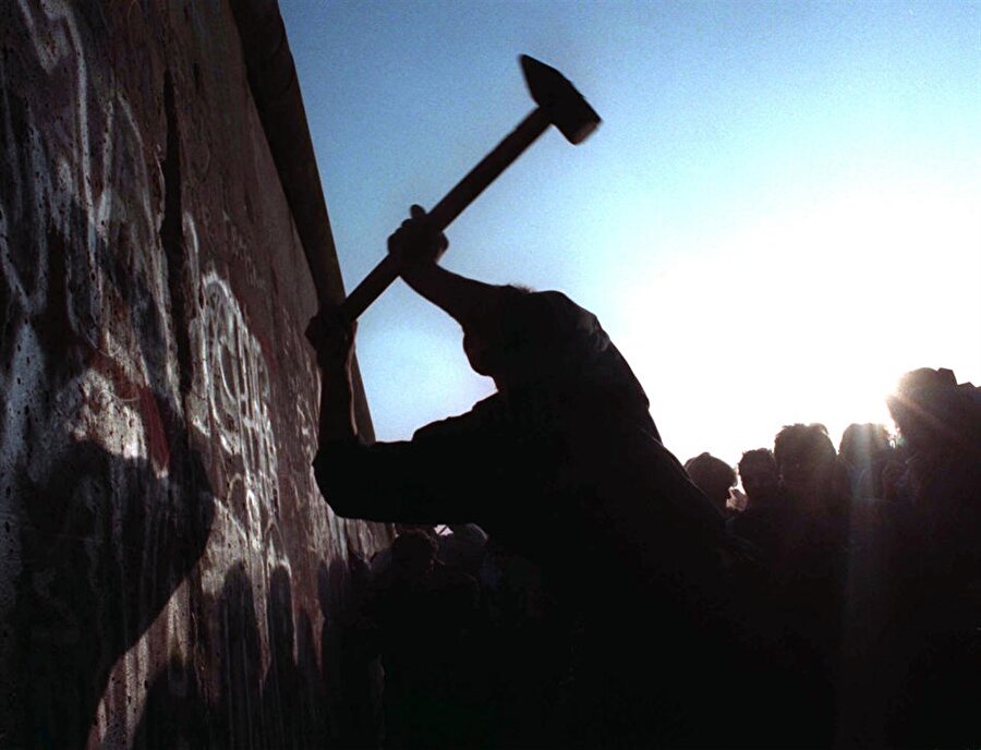 Berlin Duvarı'nın yıkımında balyozuyla çalışan bir Alman vatandaşı.