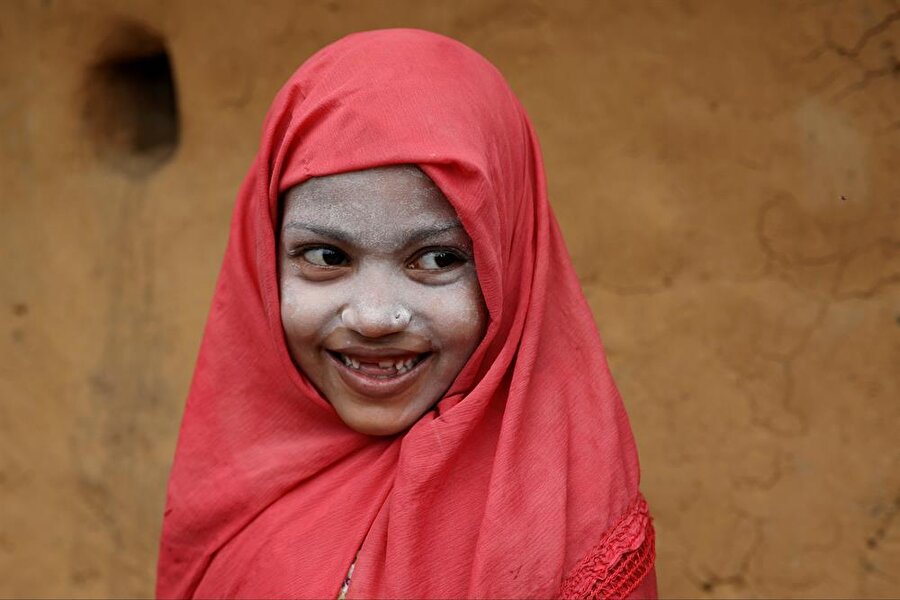Rohingyalı mülteci kız kameralara gülümsüyor. 