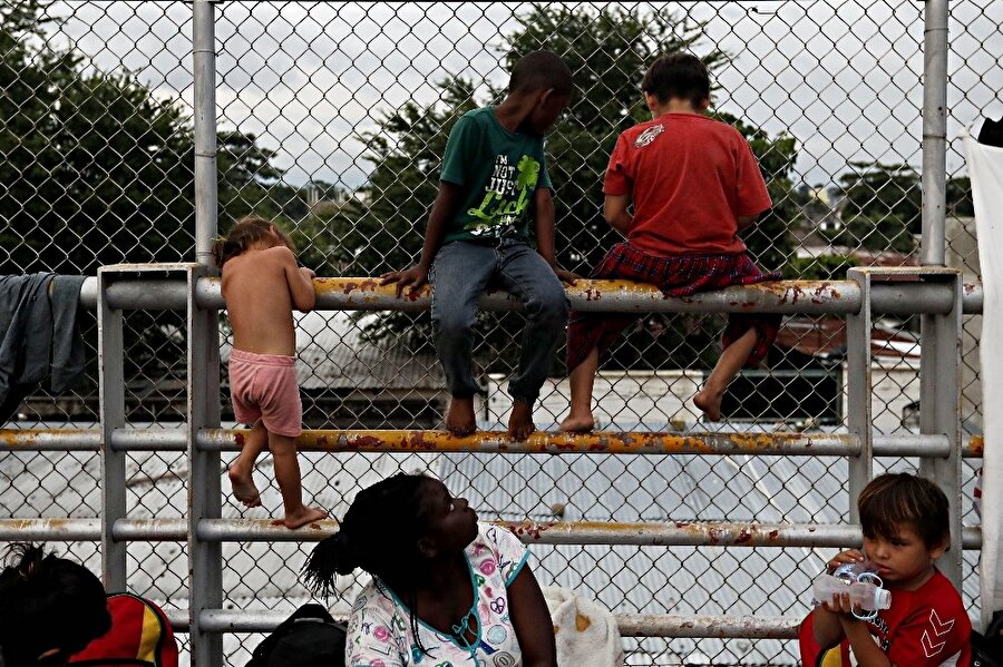 Bazı göçmenler tel örgüleri aşarak Meksika'ya girmeye çalışıyor.
