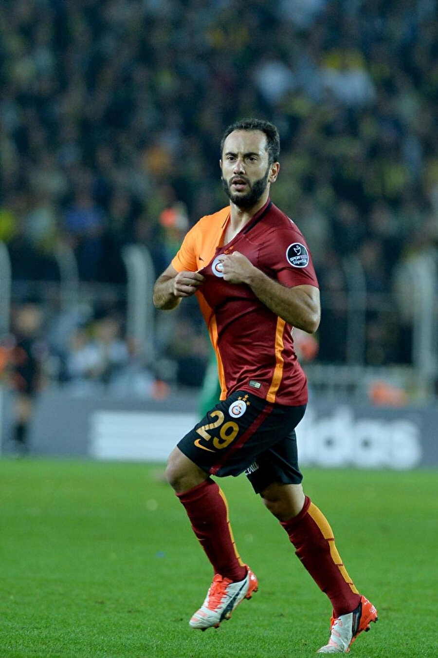 Galatasaray'ın Fenerbahçe'ye attığı son golde imzası bulunan Olcan Adın o golü armasını işaret ederek kutluyor.