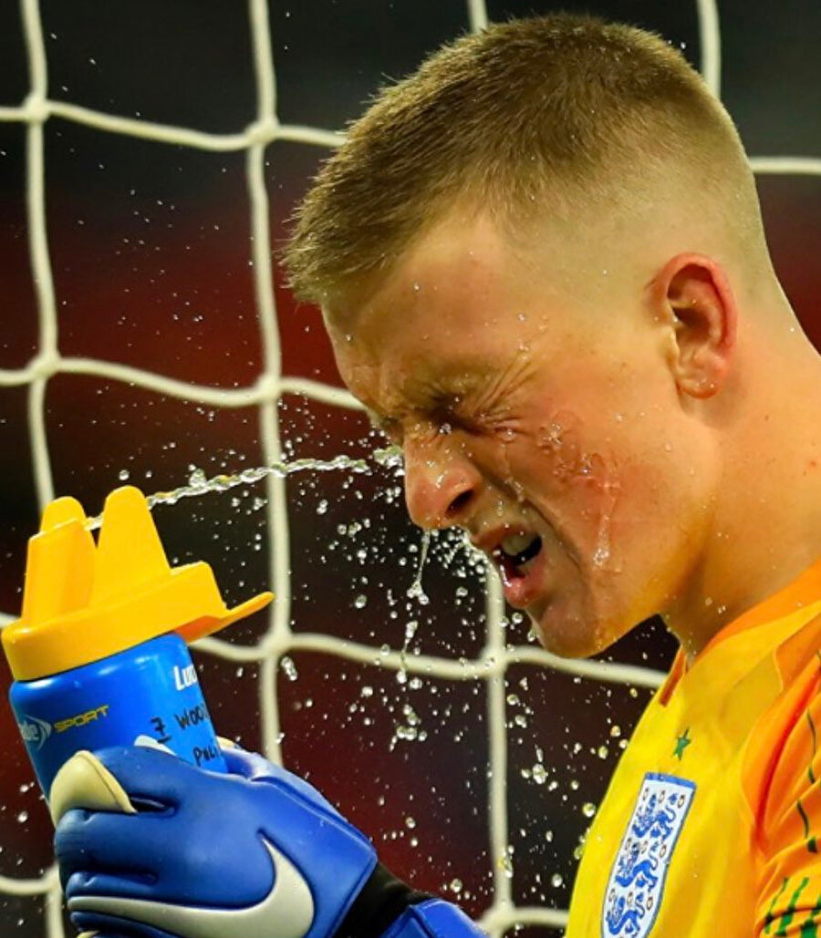 Jordan Pickford, ABD maçında oyun durduğu anda yüzüne su sıkarak serinliyor.