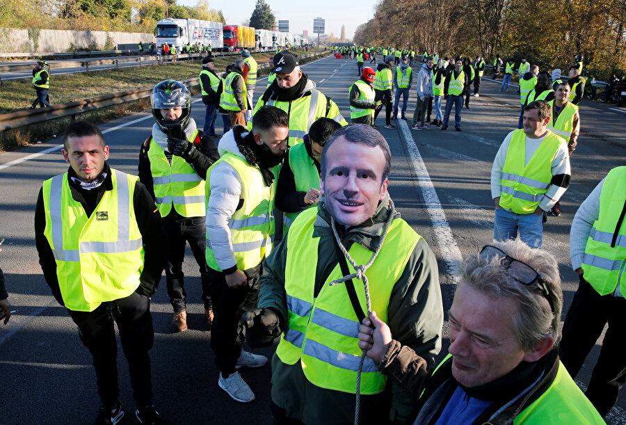 Protestoculardan bazıları Cumhurbaşkanı Macron'un maskelerini taktı.