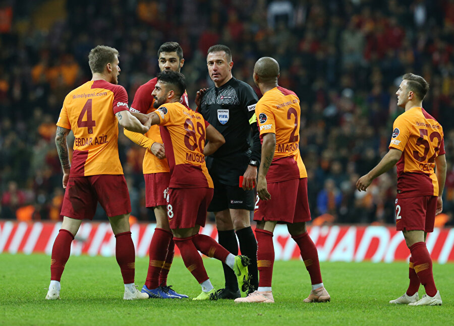 Galatasaraylı oyuncular penaltı pozisyonunda Hüseyin Göçek'e itiraz ediyor.