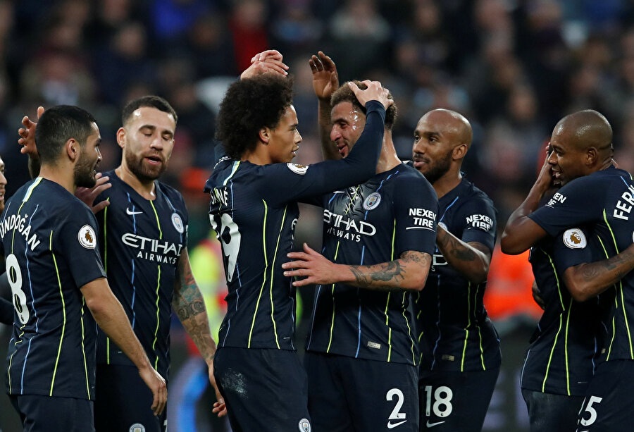 Manchester City forması giyen futbolcular galibiyeti birbirleriyle kutluyor.