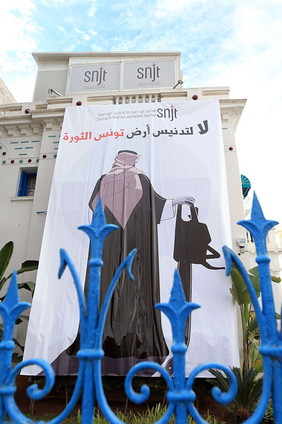 Tunuslular Bin Selman'ın elektrikli testereyle resm edildiği bir dev bir pankarta "Devrim toprağı Tunus'un kirletilmesine, hayır" diye yazdılar.